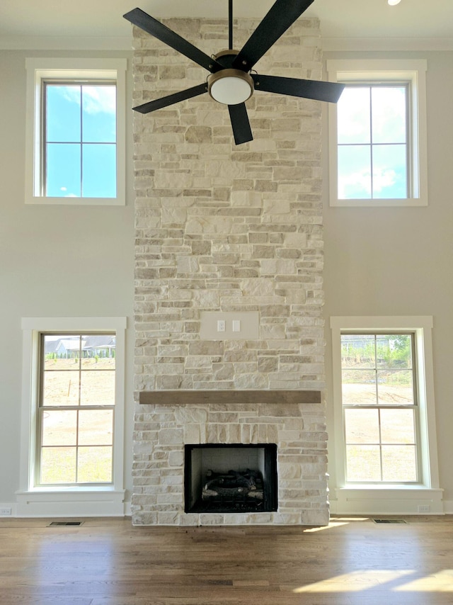 3297 Grassland Cir Unit 7, Apison, TN 37302 - unfurnished living room with visible vents, a stone fireplace, ceiling fan, a high ceiling, and plenty of natural light