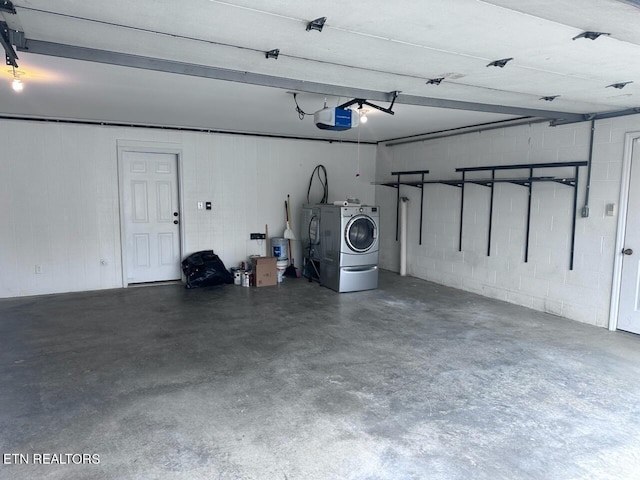 garage with a garage door opener and independent washer and dryer