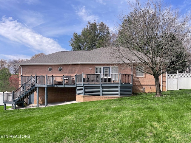 rear view of property featuring a deck and a lawn