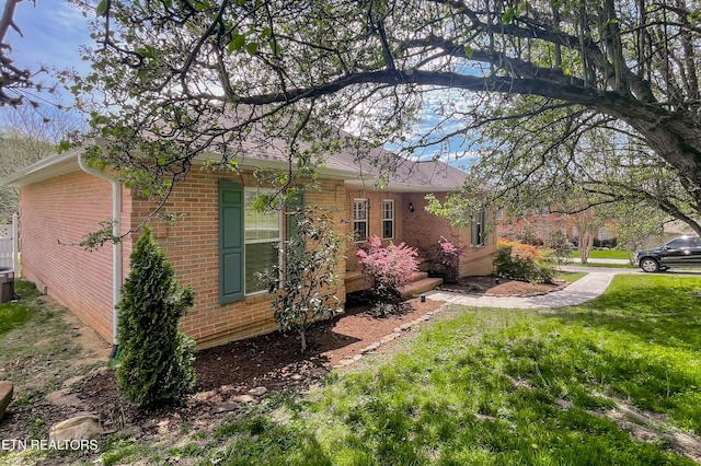 view of side of home with a yard