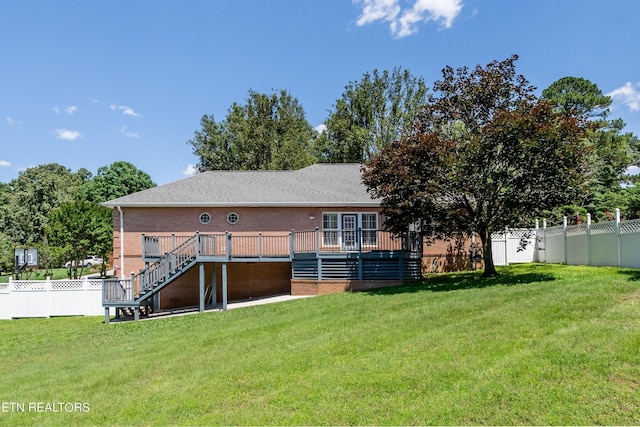 back of property with a lawn and a deck