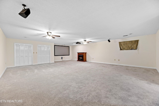 unfurnished living room featuring light carpet and a textured ceiling