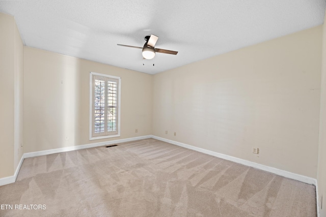 carpeted spare room with a textured ceiling and ceiling fan