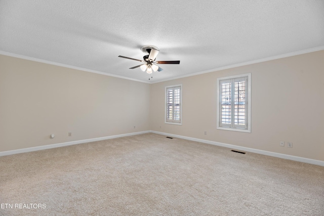 carpeted empty room featuring crown molding, ceiling fan, and a textured ceiling