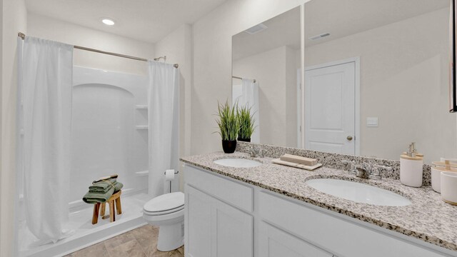 bathroom featuring vanity, toilet, and curtained shower