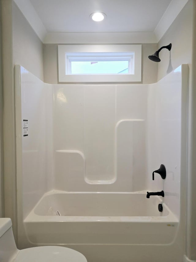 bathroom with toilet, a healthy amount of sunlight, and shower / bath combination