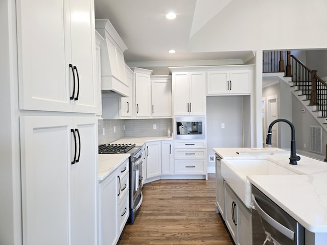 kitchen featuring appliances with stainless steel finishes, custom exhaust hood, and white cabinets