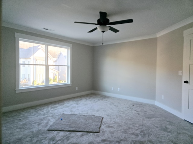 carpeted spare room with ceiling fan and ornamental molding