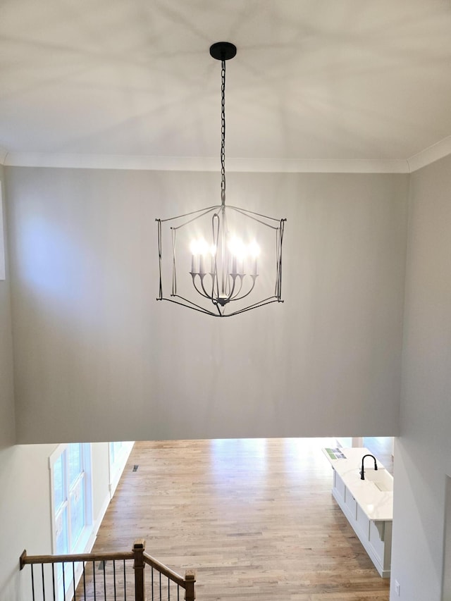 unfurnished dining area with light hardwood / wood-style flooring, ornamental molding, and a chandelier