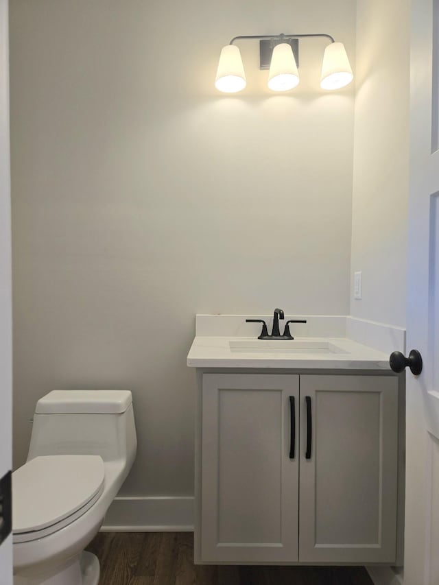 bathroom with wood-type flooring, toilet, and vanity