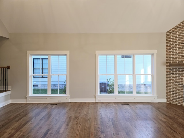 unfurnished living room featuring lofted ceiling and dark hardwood / wood-style floors