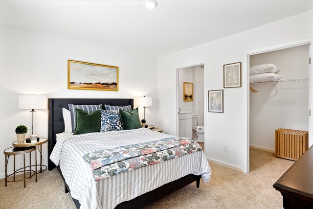 bedroom featuring light carpet, a walk in closet, a closet, connected bathroom, and radiator