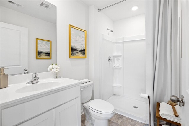 bathroom featuring vanity, toilet, and curtained shower