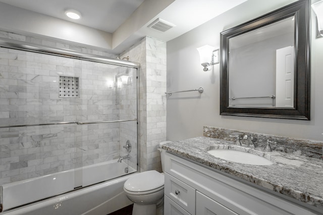 full bathroom featuring toilet, bath / shower combo with glass door, and vanity