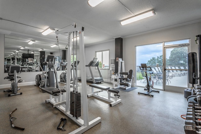 workout area with a textured ceiling, crown molding, and baseboards