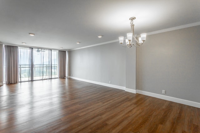 empty room with dark wood-type flooring, floor to ceiling windows, a chandelier, and ornamental molding