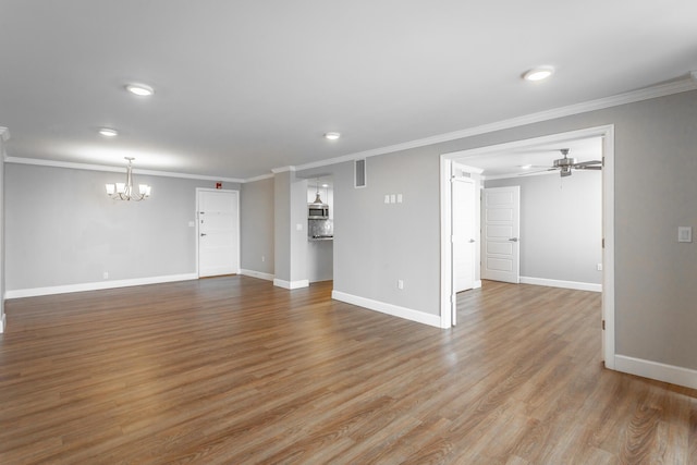 unfurnished living room featuring crown molding, wood finished floors, and baseboards