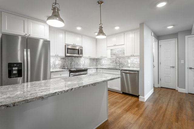 kitchen featuring white cabinets, pendant lighting, stainless steel appliances, and sink