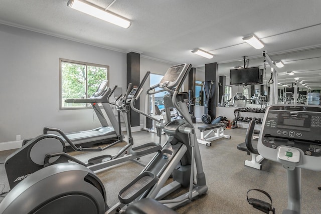 workout area featuring ornamental molding, baseboards, and a textured ceiling