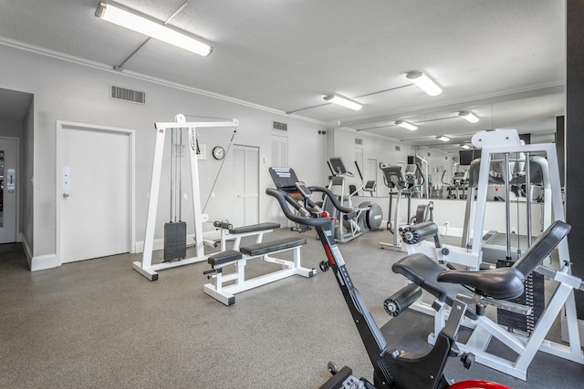 exercise room with a textured ceiling, visible vents, and ornamental molding