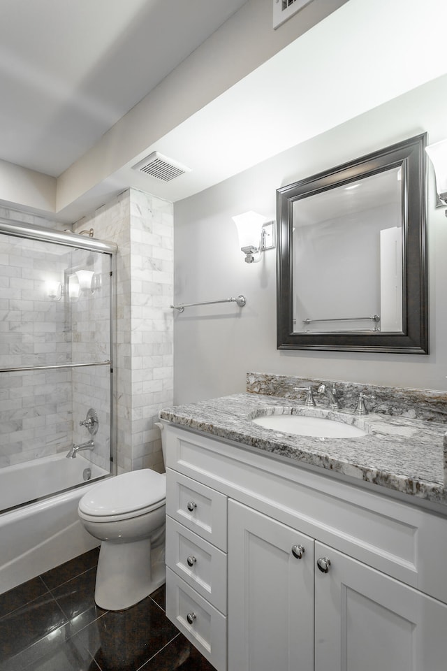 full bathroom with tile patterned floors, vanity, toilet, and combined bath / shower with glass door