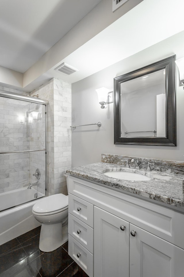 full bathroom featuring visible vents, combined bath / shower with glass door, toilet, and vanity