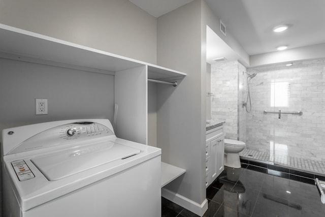 clothes washing area featuring washer / clothes dryer and dark tile patterned flooring