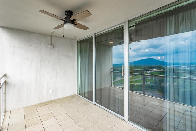 balcony featuring a mountain view and a ceiling fan