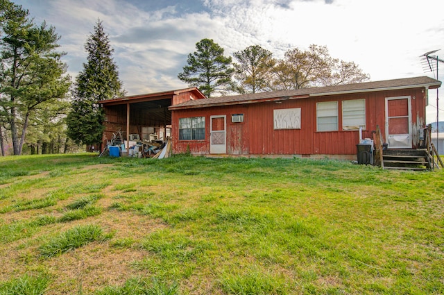 back of property with a yard and a carport