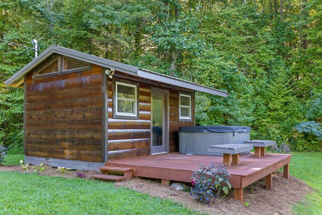 exterior space featuring a yard, a shed, and a hot tub