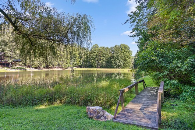 view of community with a water view and a lawn