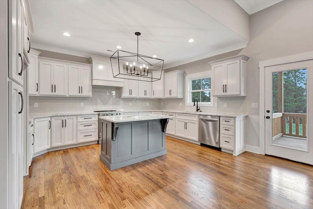 kitchen featuring light wood-type flooring, dishwasher, light stone counters, an inviting chandelier, and a center island