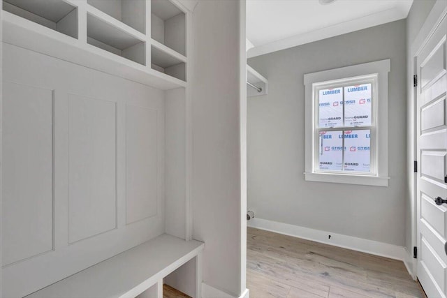 mudroom featuring light wood-type flooring and crown molding