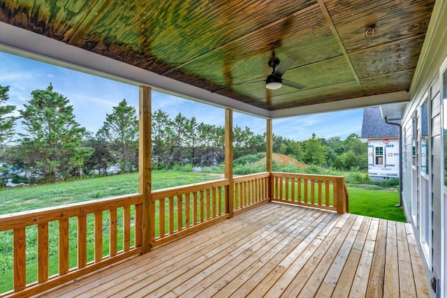 wooden terrace featuring a lawn and ceiling fan