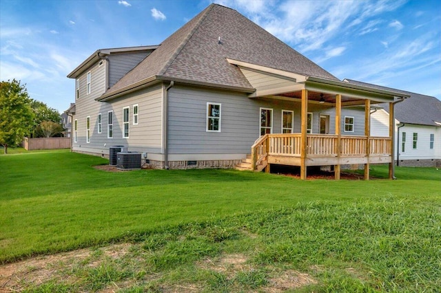 rear view of house with a yard and central AC unit