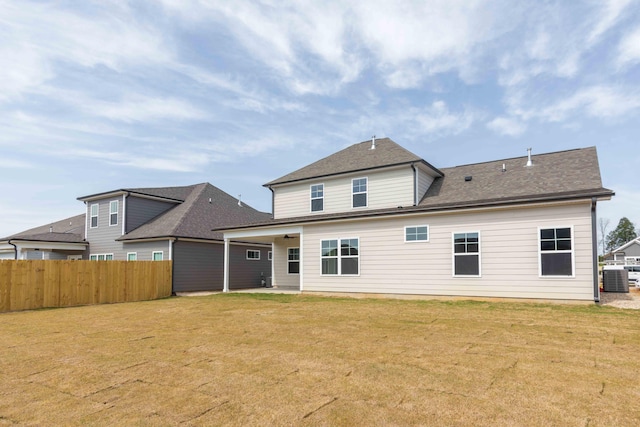 back of house featuring central AC unit and a yard