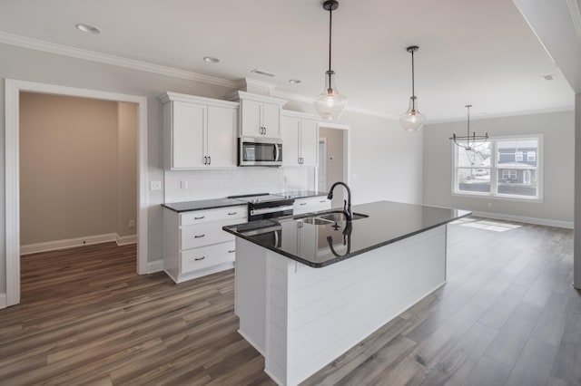 kitchen featuring white cabinetry, pendant lighting, a kitchen island with sink, dark hardwood / wood-style floors, and sink