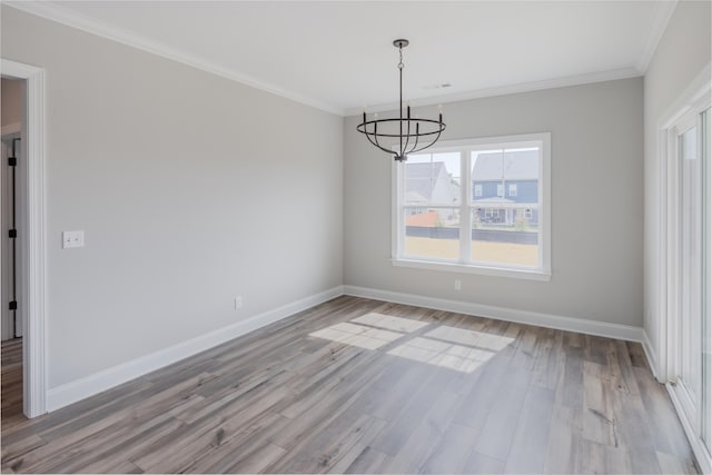 unfurnished dining area featuring light wood-type flooring, crown molding, and a notable chandelier