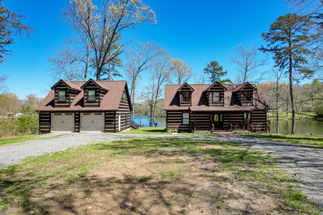 log home featuring a water view, a garage, and a front yard