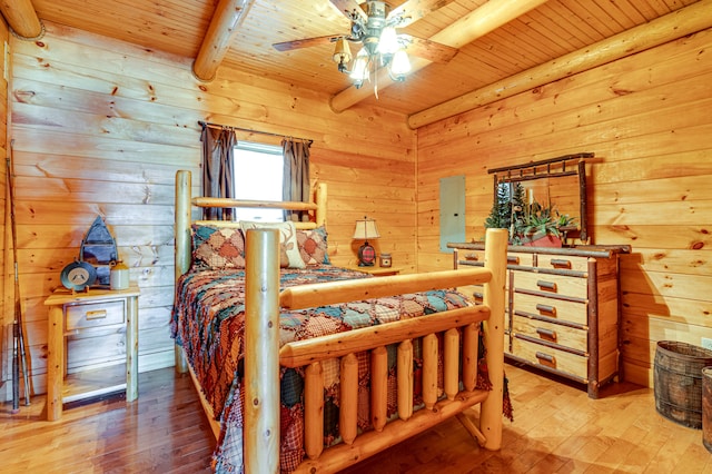 bedroom with ceiling fan, beamed ceiling, light wood-type flooring, and wooden ceiling