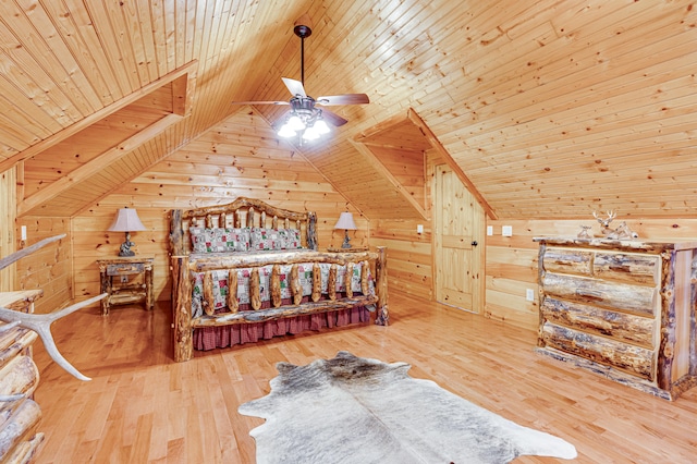 bedroom with light hardwood / wood-style flooring, vaulted ceiling, wooden walls, and wooden ceiling