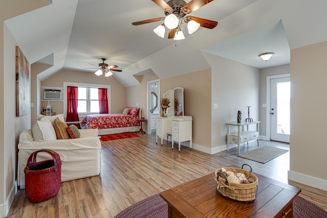 living room featuring light wood-type flooring, vaulted ceiling, a wall mounted air conditioner, and ceiling fan