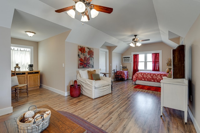 living room featuring ceiling fan, hardwood / wood-style flooring, and vaulted ceiling