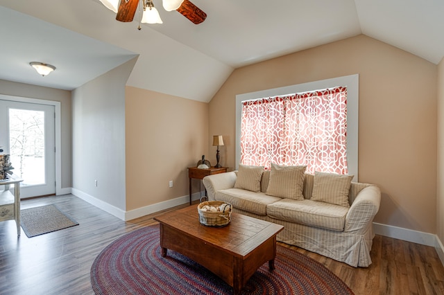 living room featuring ceiling fan, wood-type flooring, and vaulted ceiling