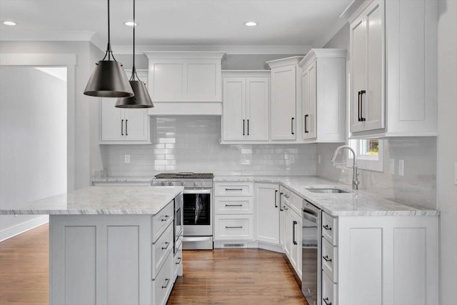 kitchen with wood finished floors, stainless steel appliances, custom range hood, and a sink