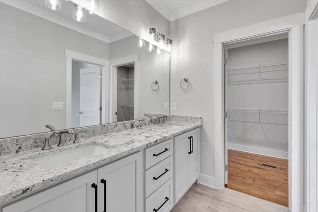 bathroom featuring vanity, ornamental molding, and hardwood / wood-style flooring