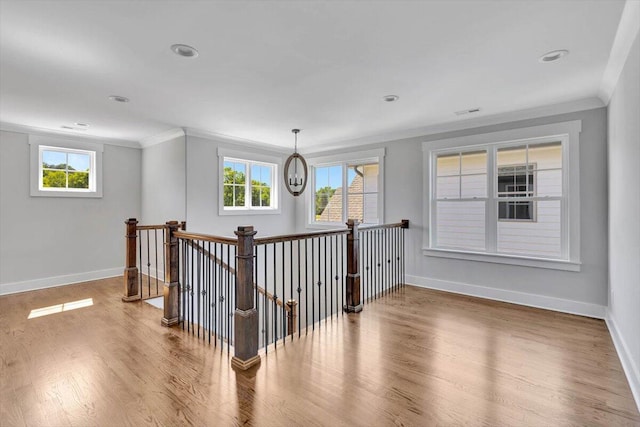 interior space featuring hardwood / wood-style floors, a wealth of natural light, a chandelier, and ornamental molding