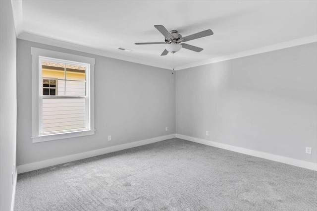 carpeted spare room featuring ceiling fan and ornamental molding