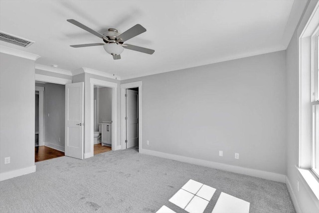 unfurnished bedroom with ensuite bath, crown molding, ceiling fan, and carpet floors