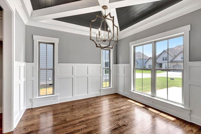 unfurnished dining area featuring a chandelier, plenty of natural light, and a decorative wall